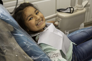 a little girl sitting on the floor with her mouth open