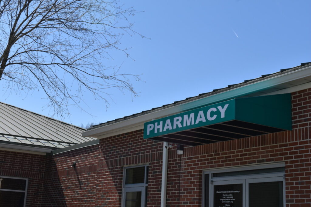 a pharmacy building with a green awning
