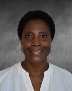 a woman in a white shirt smiling at the camera