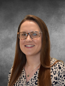 a woman wearing glasses and a leopard print shirt