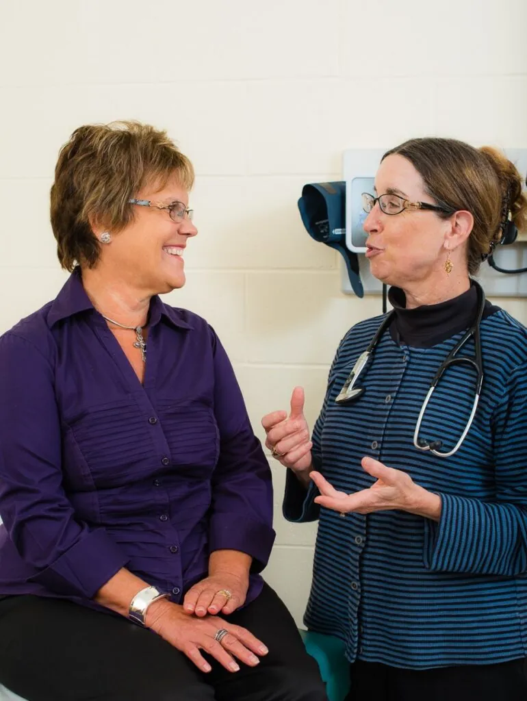 two women talking to each other in a room