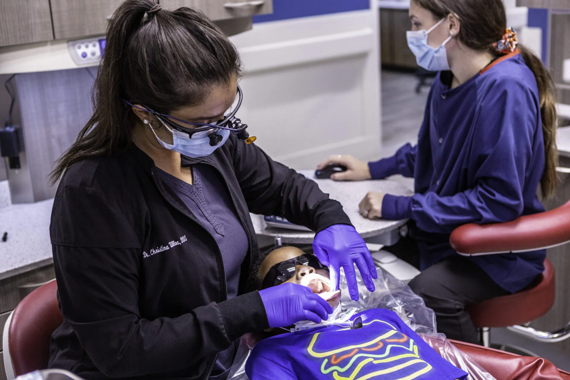A dentist checking the teeth of a child