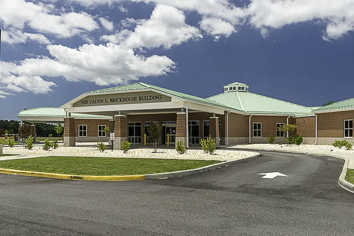 a large building with a green roof on a cloudy day