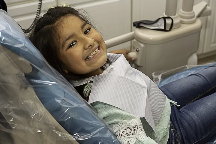 a little girl sitting on the floor with her mouth open