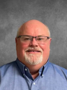 a bald man with glasses and a blue shirt