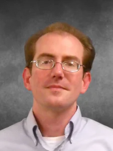 a man wearing glasses and a white shirt