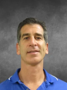 a man in a blue shirt is looking at the camera
