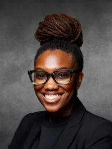 a woman with glasses smiling for the camera