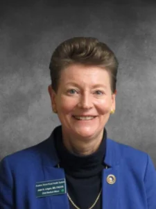 a woman in a blue jacket smiling for the camera