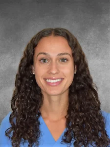 a woman with long curly hair wearing a blue shirt