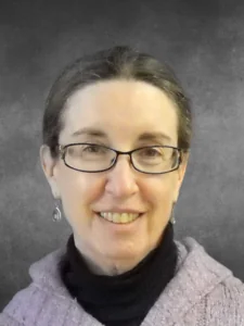 a woman wearing glasses and smiling for the camera