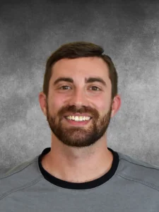 a man with a beard smiling at the camera