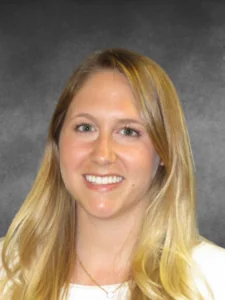 a woman with long blonde hair smiling at the camera