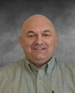 a bald man with a green and yellow checkered shirt