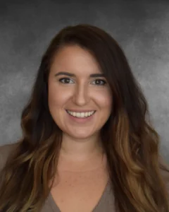 a woman with long hair and a brown shirt