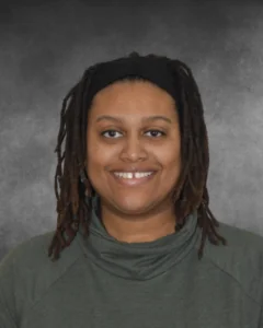a woman with dreadlocks is smiling for a picture