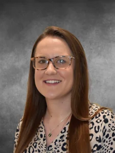 a woman wearing glasses and a leopard print shirt